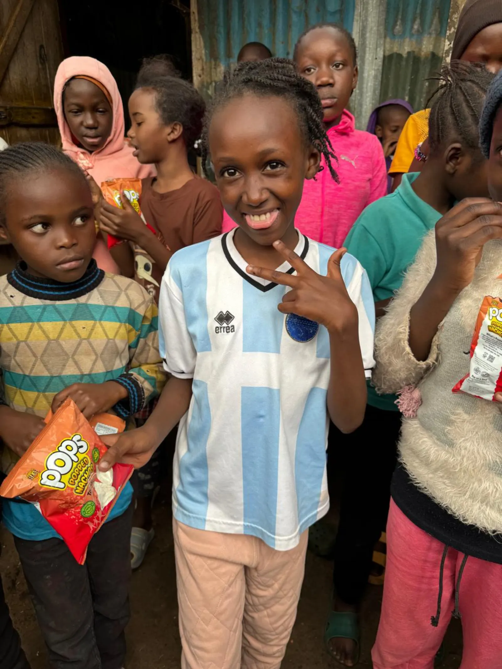 A girl smiling among children at a community outreach